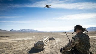 Personnel look out to aircraft in distance.